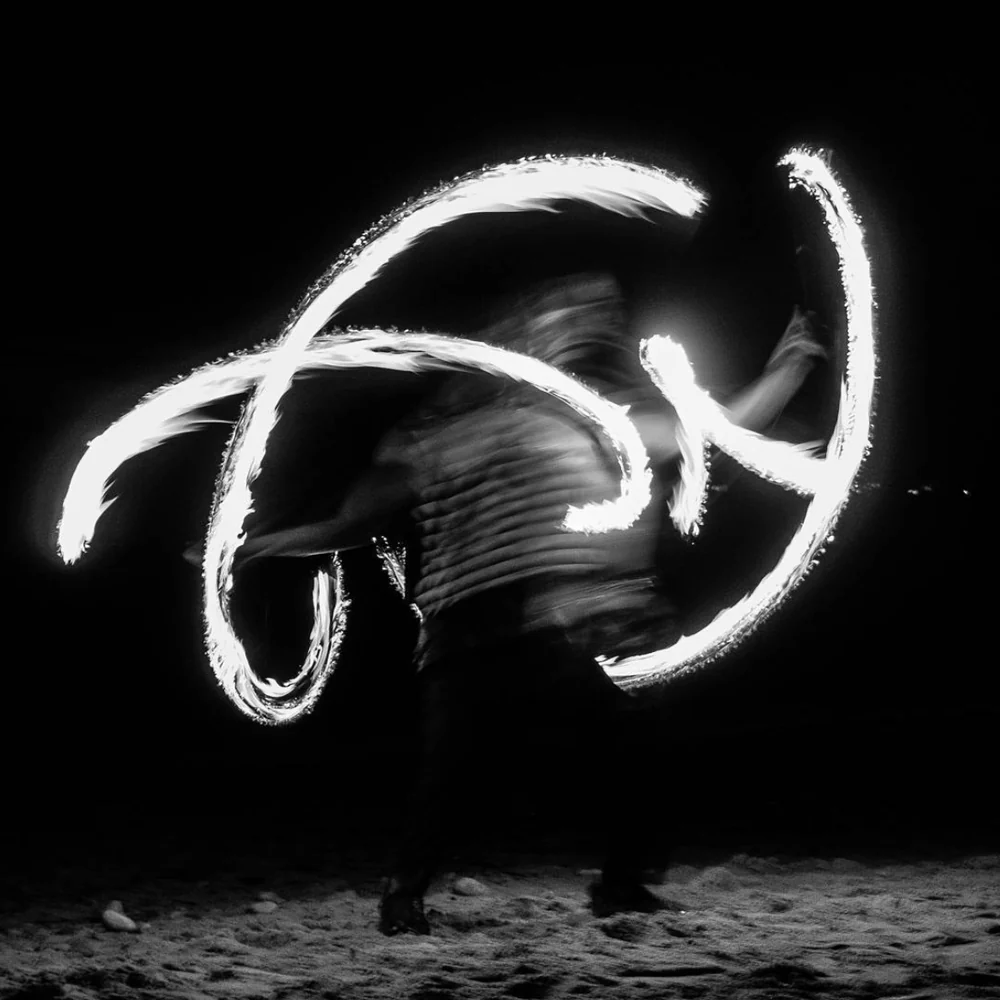 Light painting at night, a person drawing loops of fire